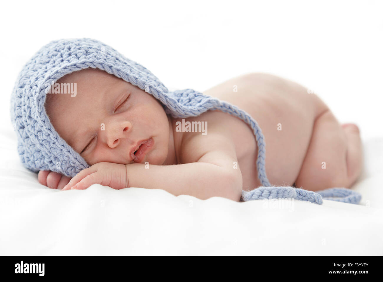 Sleeping newborn baby wearing a blue hat. Stock Photo