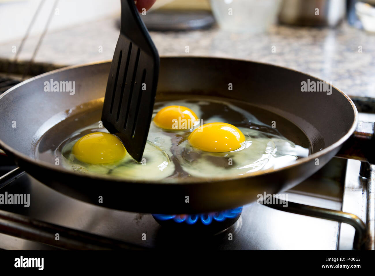 Fried eggs being cooked Stock Photo - Alamy