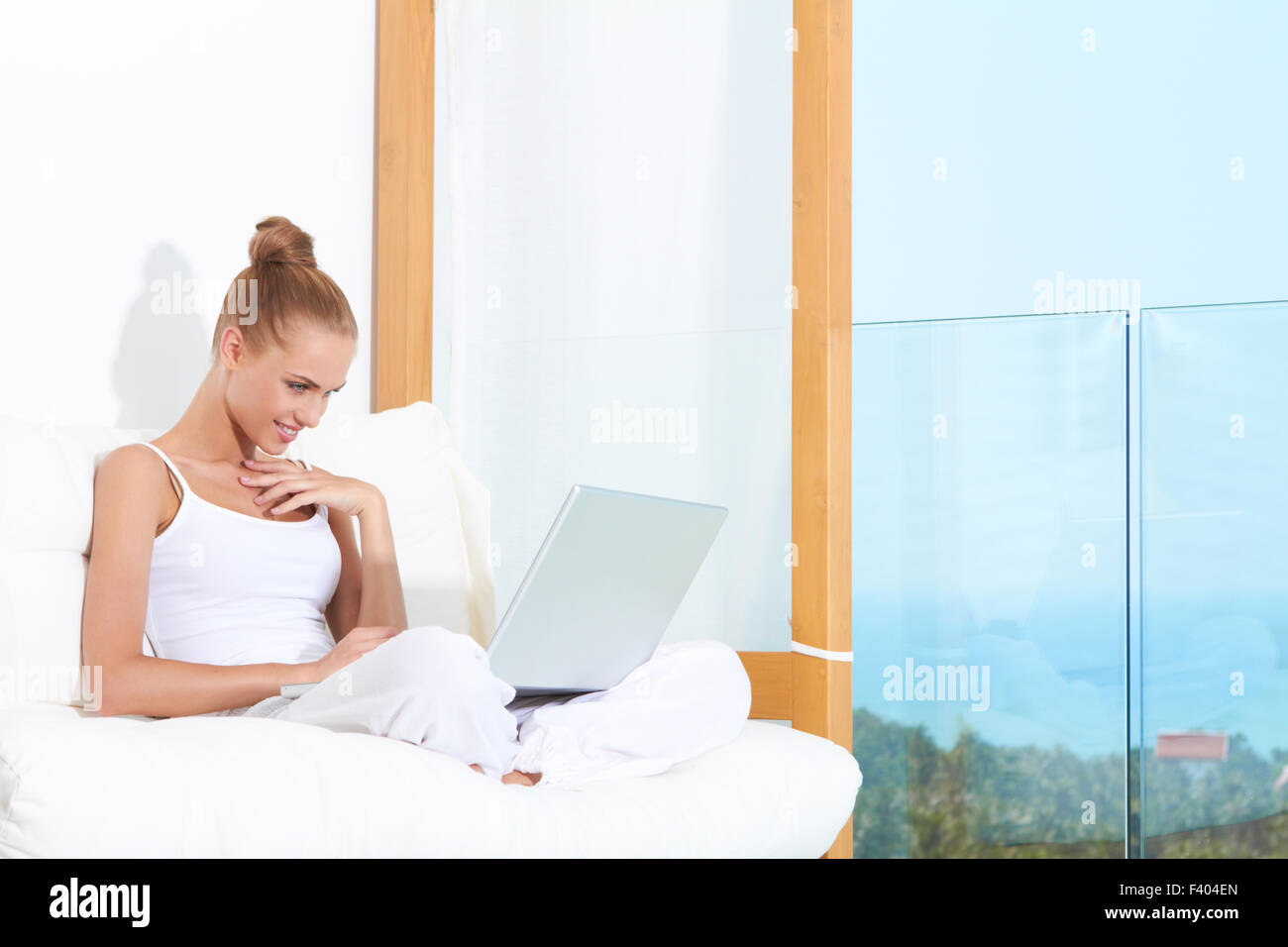 Smiling Woman Chatting on Laptop at Couch Stock Photo