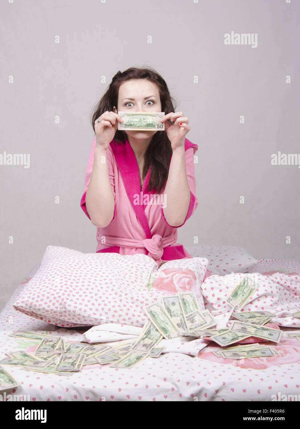 Girl sitting on the bed rejoices money Stock Photo Alamy