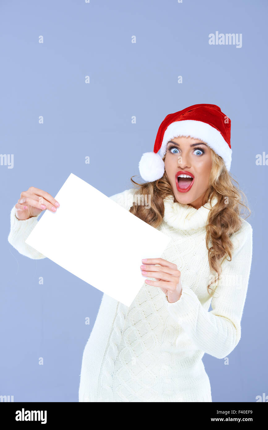 Blond Woman Holding Blank Paper in Surprise Face Stock Photo