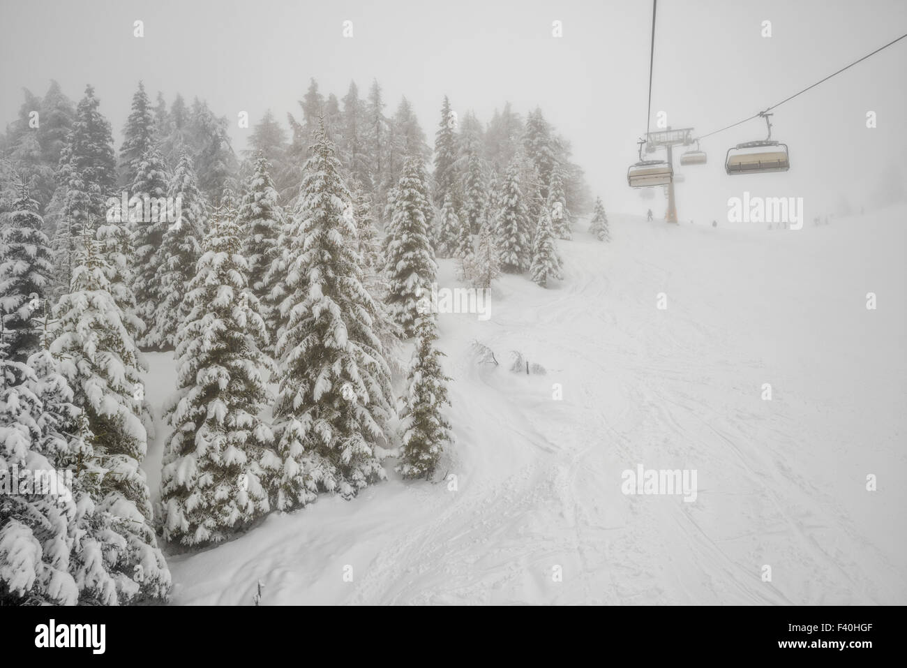 Chairlift in snowfall at alpine ski resort Stock Photo