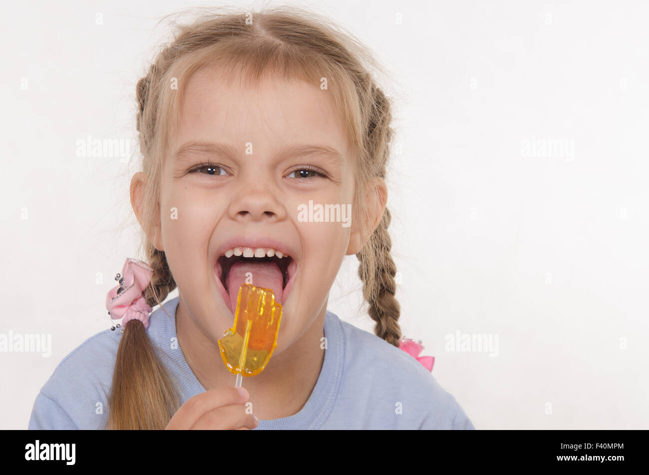Funny girl licking a lollipop Stock Photo