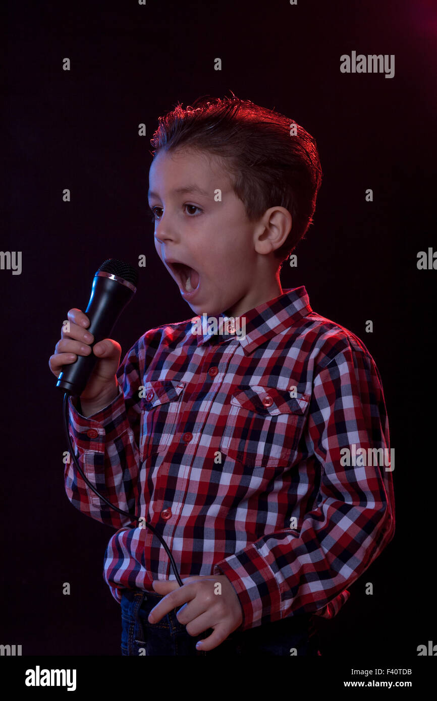 boy yelling in microphone Stock Photo