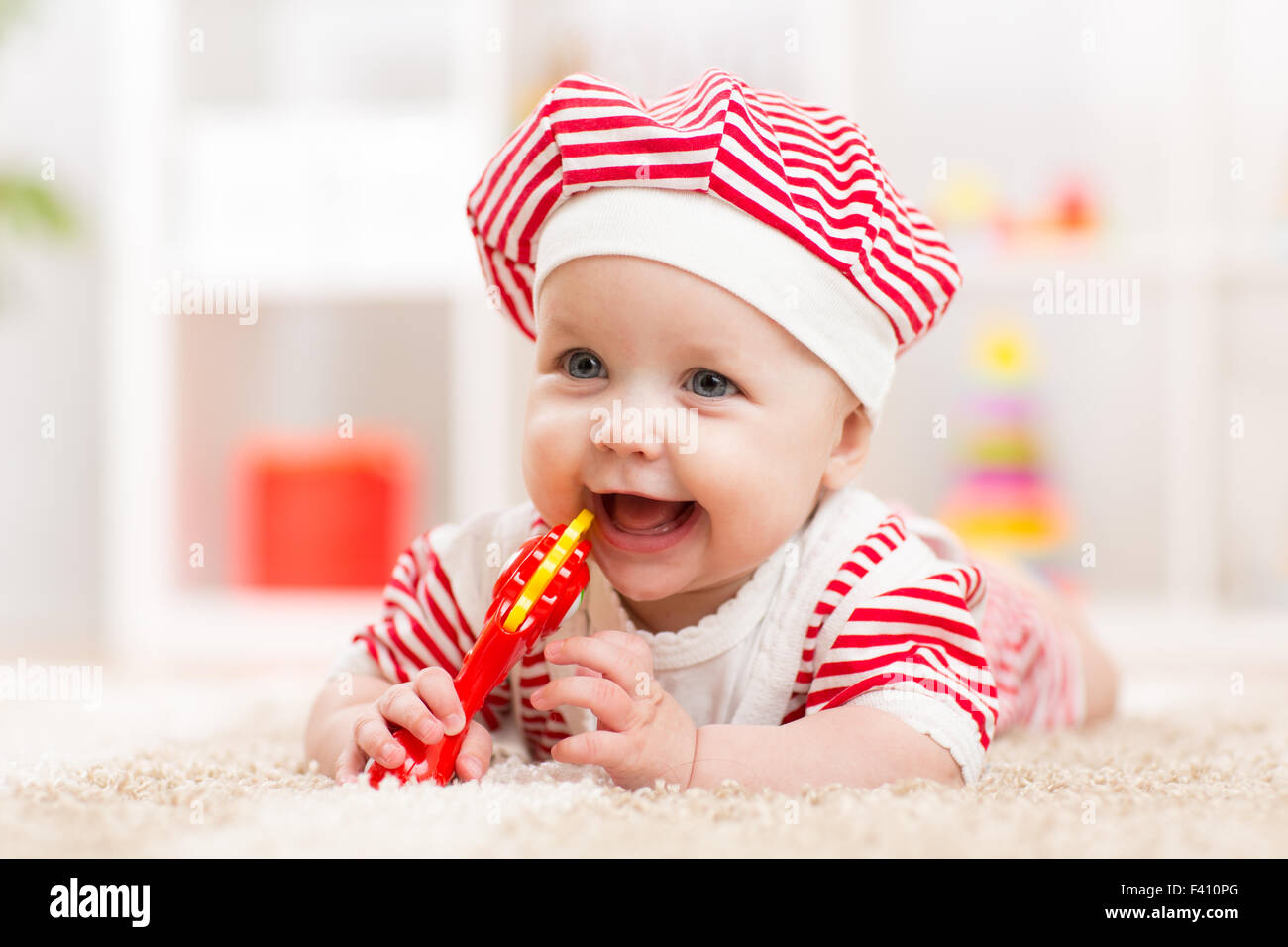 Little girl lying on bed playing with baby girl hires stock