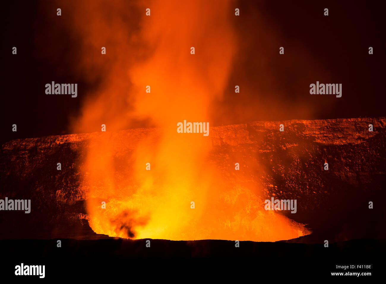 Tree in silhouette at dusk, lava glowing, Kilaueea Caldera volcano, Hawai'i Volcanoes National Park, Big Island, Hawaii, USA Stock Photo