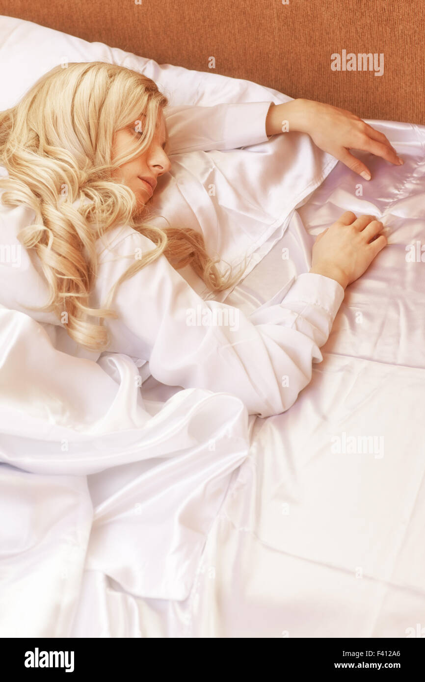 Blonde young woman in the bed Stock Photo
