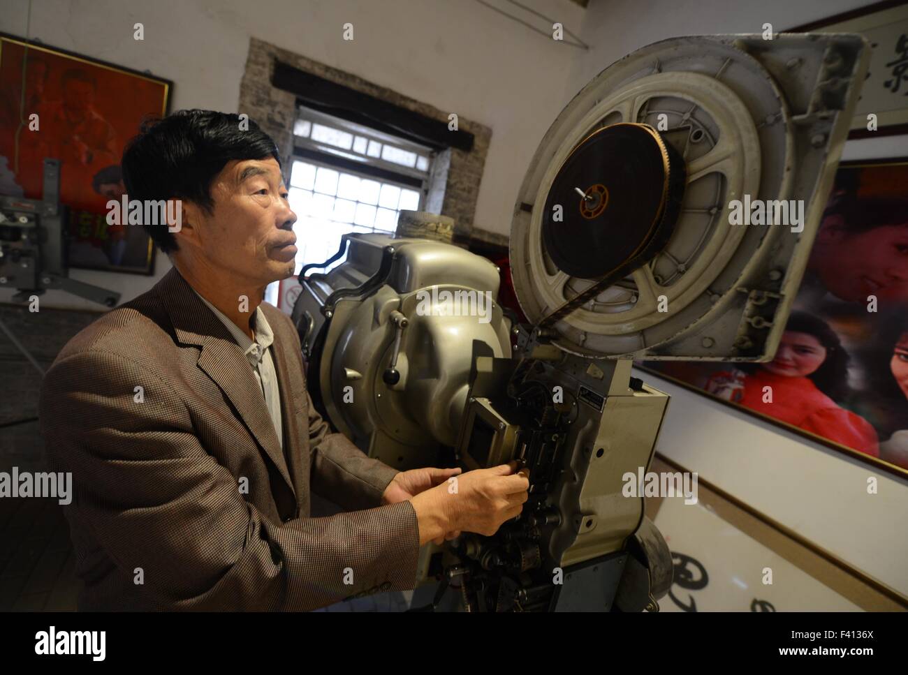 Shijiazhuang, China's Hebei Province. 13th Oct, 2015. Wei Shaoxian debugs an old film projector at his film museum in Siliugu Village of Handan County, north China's Hebei Province, Oct. 13, 2015. Cinephile Wei Shaoxian collected more than 20,000 items about film, such as filmstrip, poster and record, since 2004 and founded his private film museum in his village in 2015. © Wang Xiao/Xinhua/Alamy Live News Stock Photo