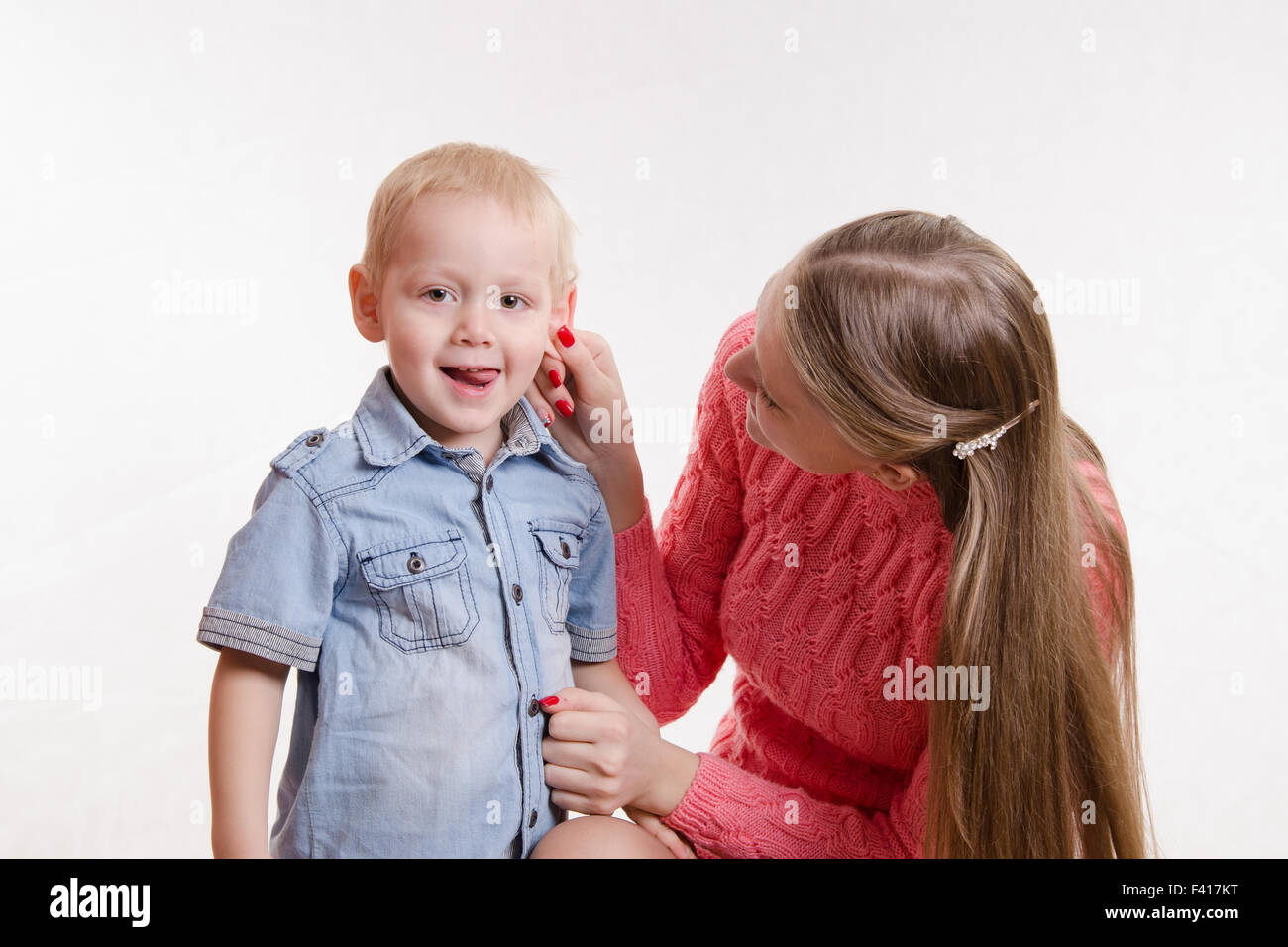 Mom playfully took his son by the ear Stock Photo