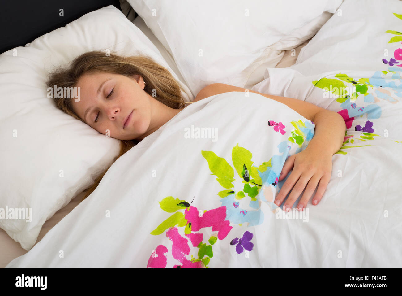 young woman asleep in bed Stock Photo
