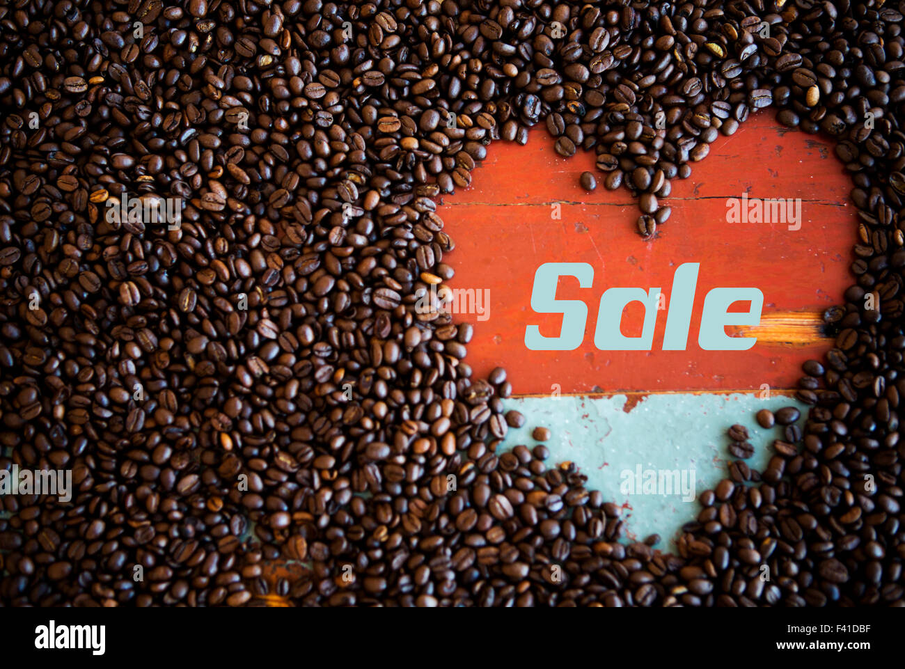 heart shape of coffee beans on a vintage wooden table with the word 'sale' Stock Photo