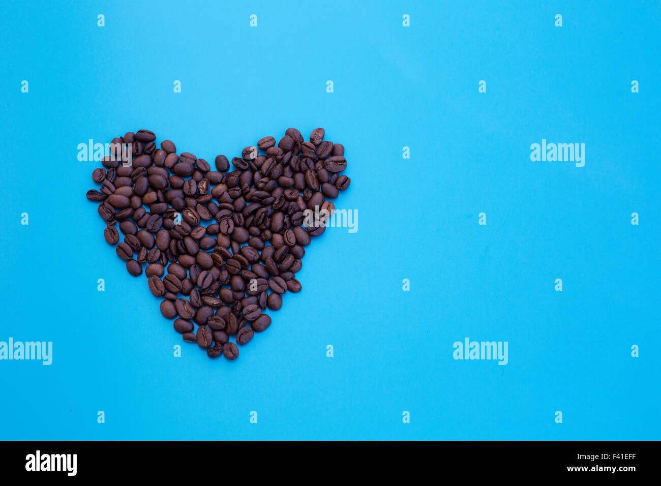 heart shape of coffee beans on blue background Stock Photo