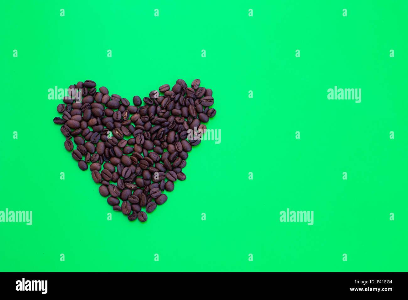 heart shape of coffee beans on green background Stock Photo