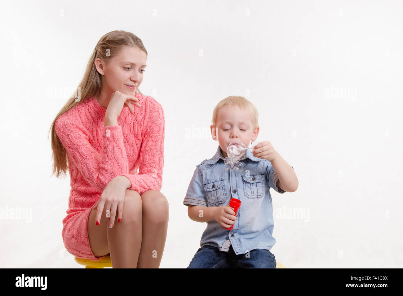 Mom watches her son to blow bubbles Stock Photo