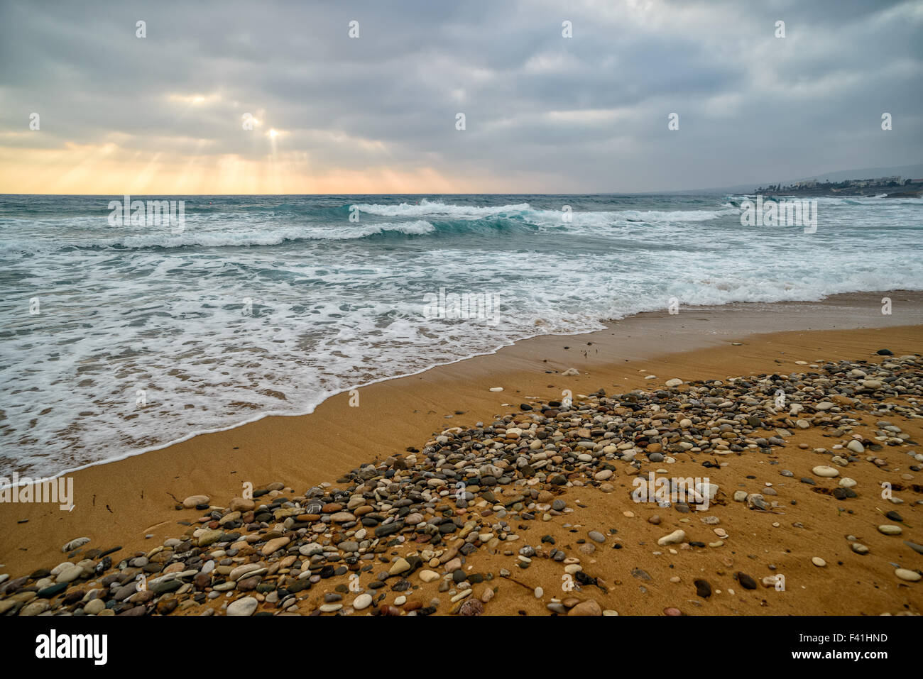 Sunset over stormy sea and empty beach Stock Photo