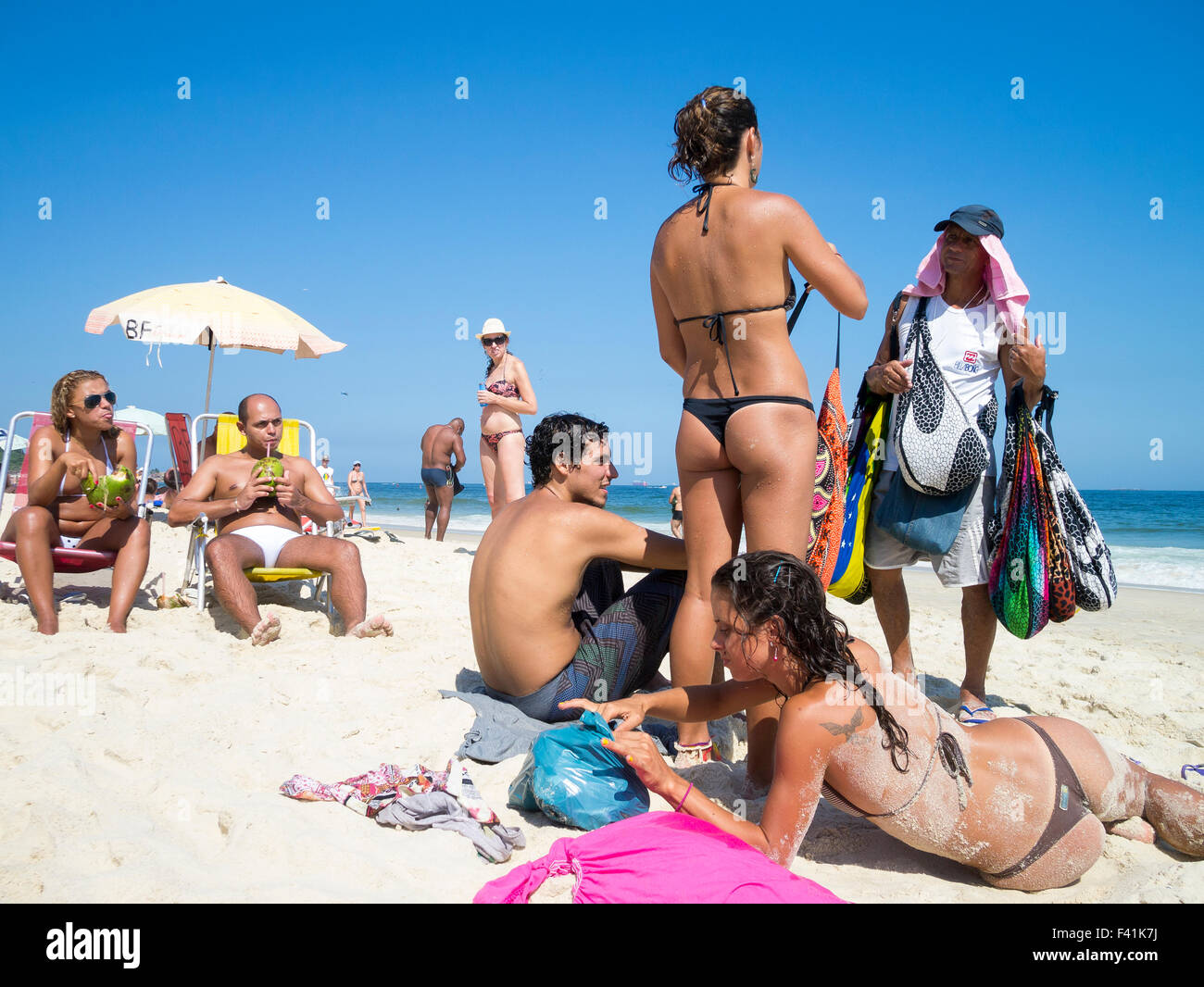 RIO DE JANEIRO, BRAZIL - MARCH 05, 2013: Vendors sell bikinis and canga  beach blankets to sunbathers on Ipanema Beach Stock Photo - Alamy