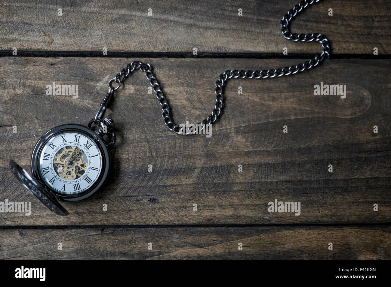 Vintage watch on a wooden background showing five to twelve, text space Stock Photo