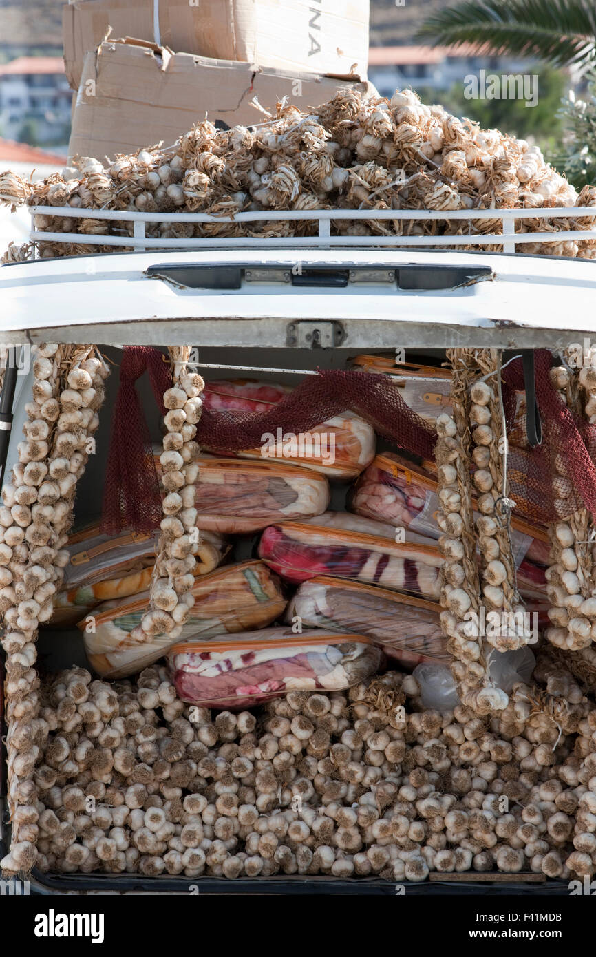 Heaps of dried hanging garlic cloves for sale among packs of blankets