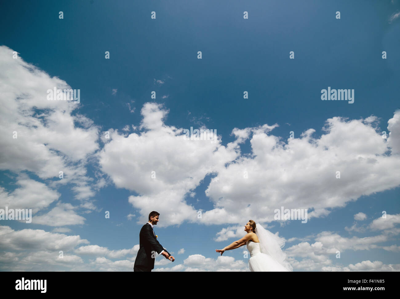 couple on blue sky background Stock Photo - Alamy