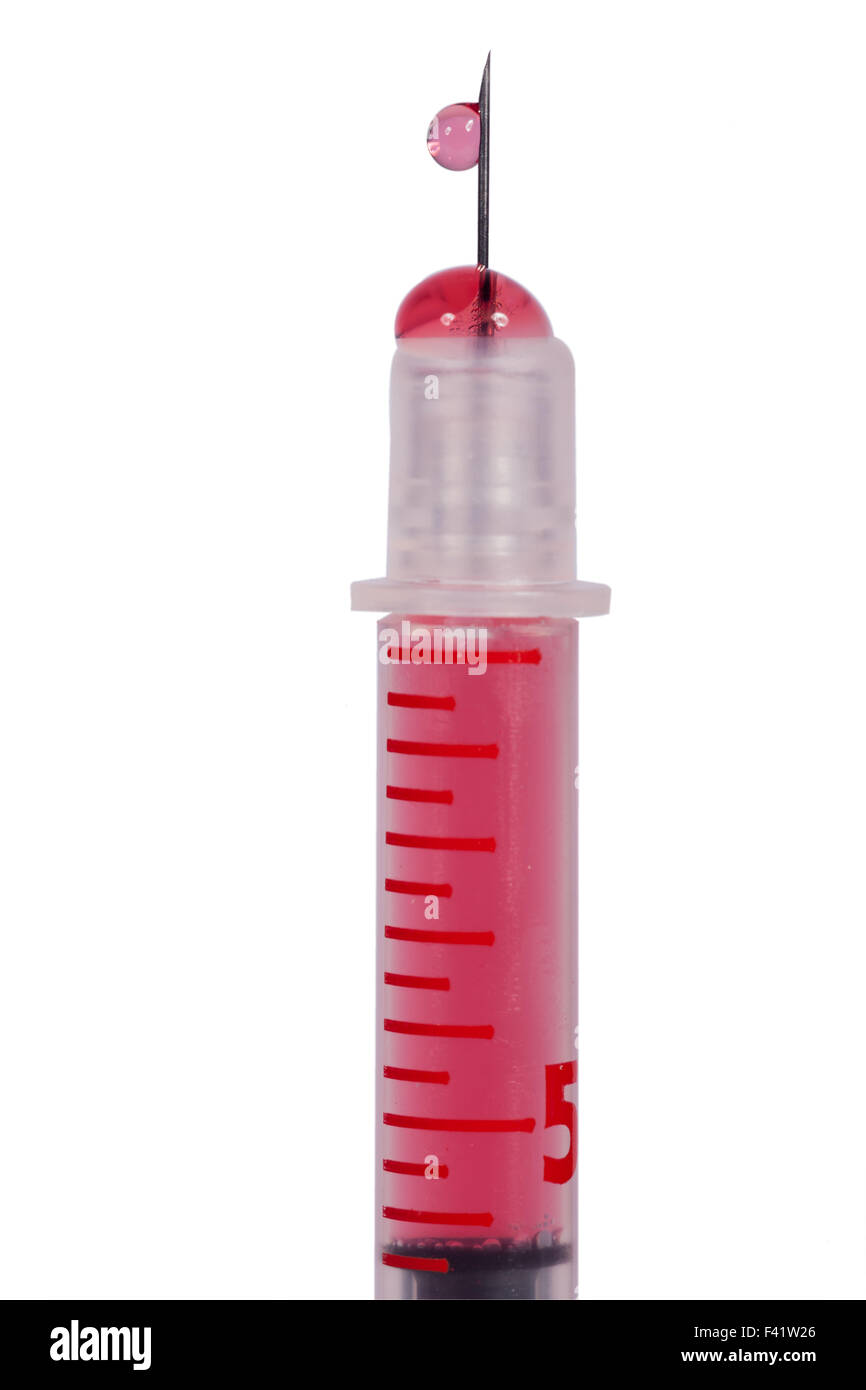 Disposable plastic hypodermic syringe and needle filled with a red