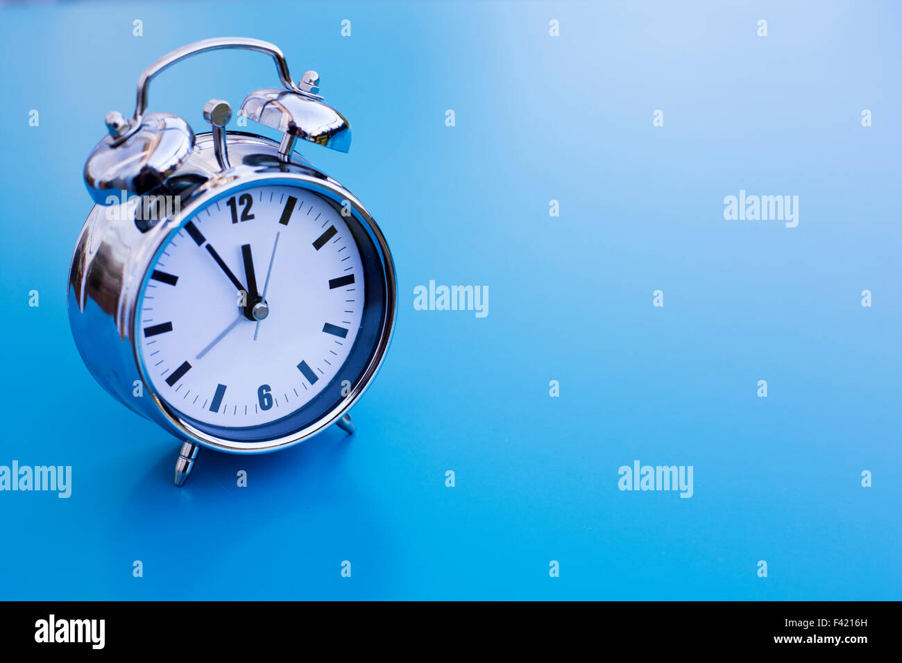 vintage alarm clock on blue table Stock Photo - Alamy