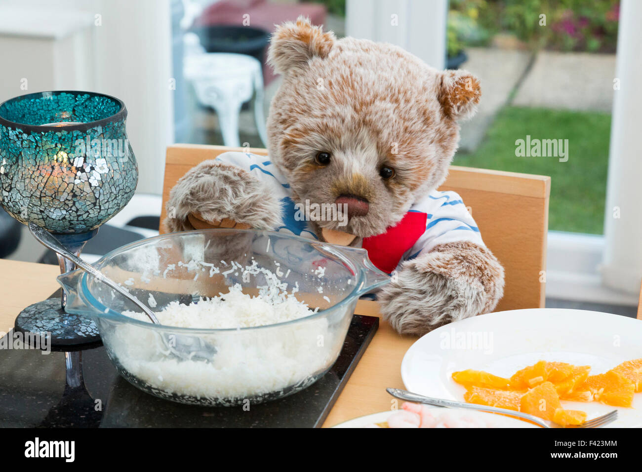 teddy bear sat at table Stock Photo
