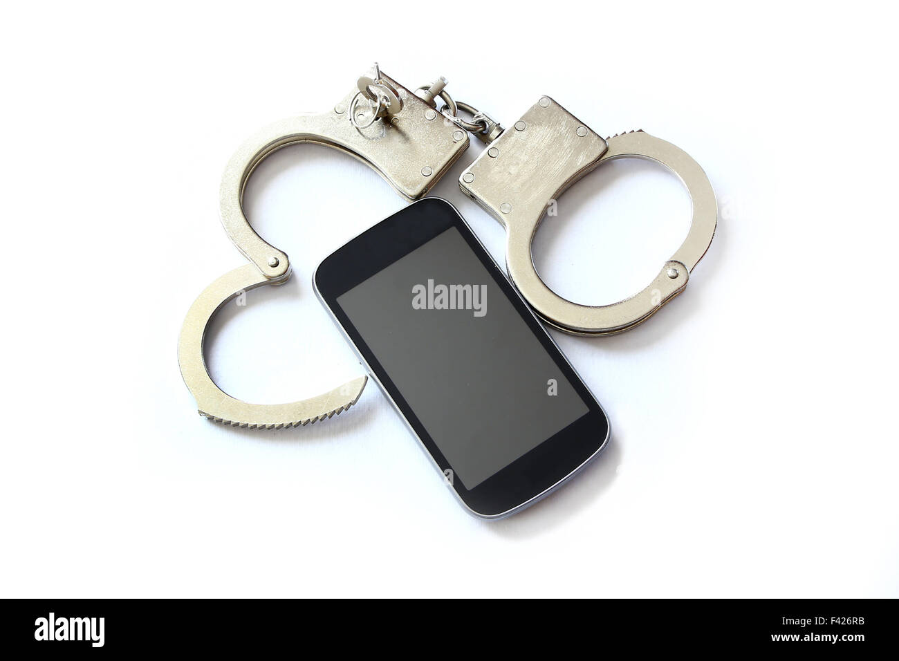 computer hacker smartphone and hand cuffs locked up on white table Stock Photo
