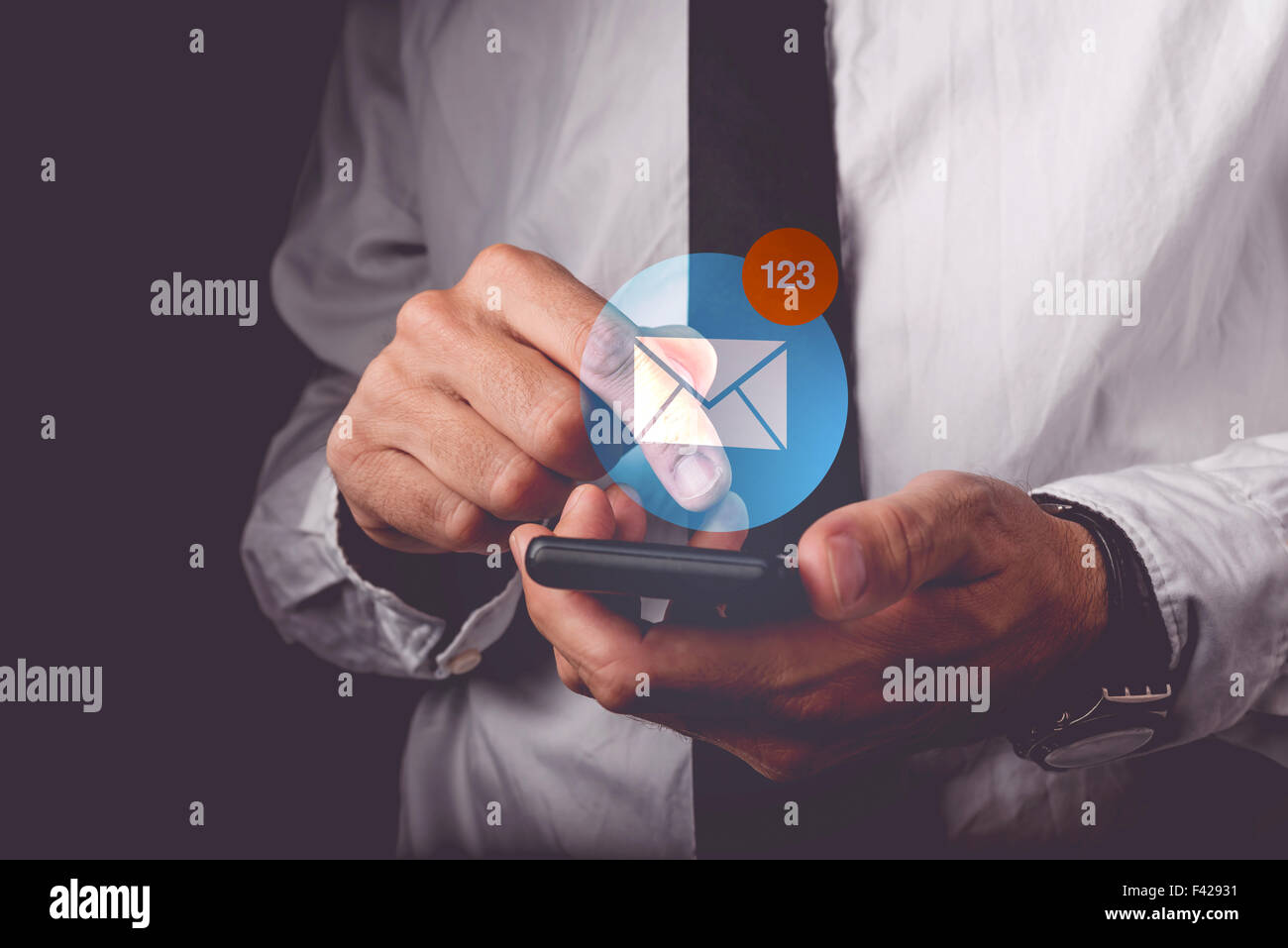 Businessman viewing e-mail messages on mobile smart phone, finger on touch screen of wireless device pushing application icon, r Stock Photo