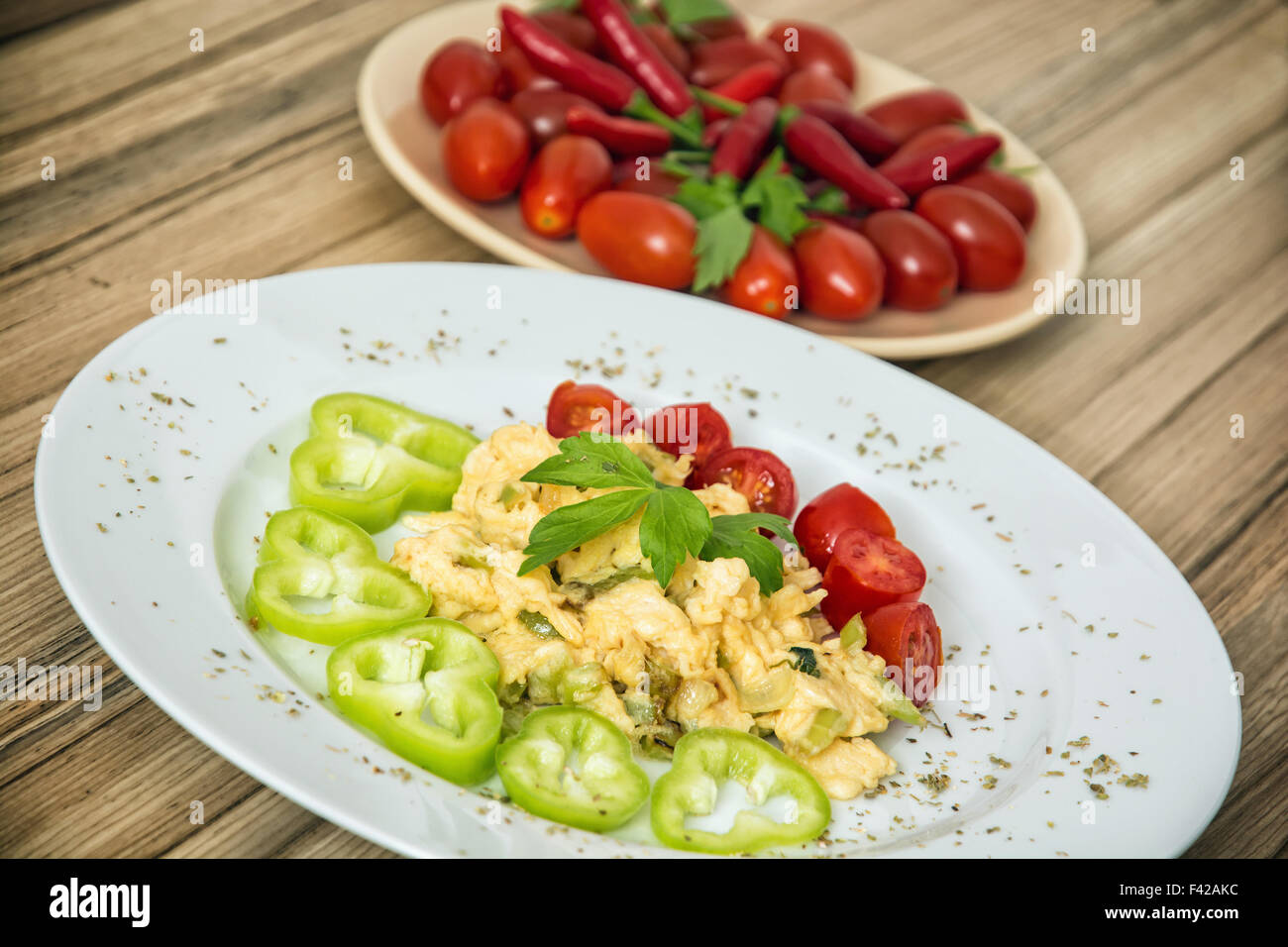 Scrambled eggs with paprika, cherry tomatoes, chili peppers and celery