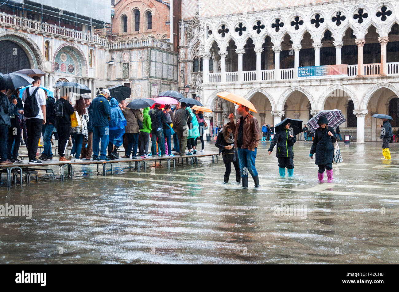 St Marks Square, Venice, Italy. 14th October 2015.People in Piazza San Marco in the rain during Acqua alta or 'high water' the exceptional tide peaks that occur periodically in the northern Adriatic Sea. Photo by:Richard Wayman Stock Photo
