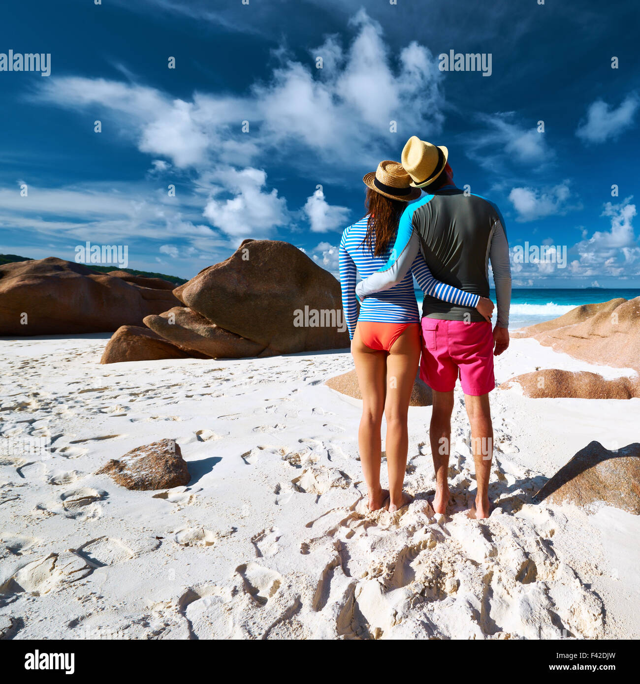 Couple at tropical beach wearing rash guard Stock Photo Alamy