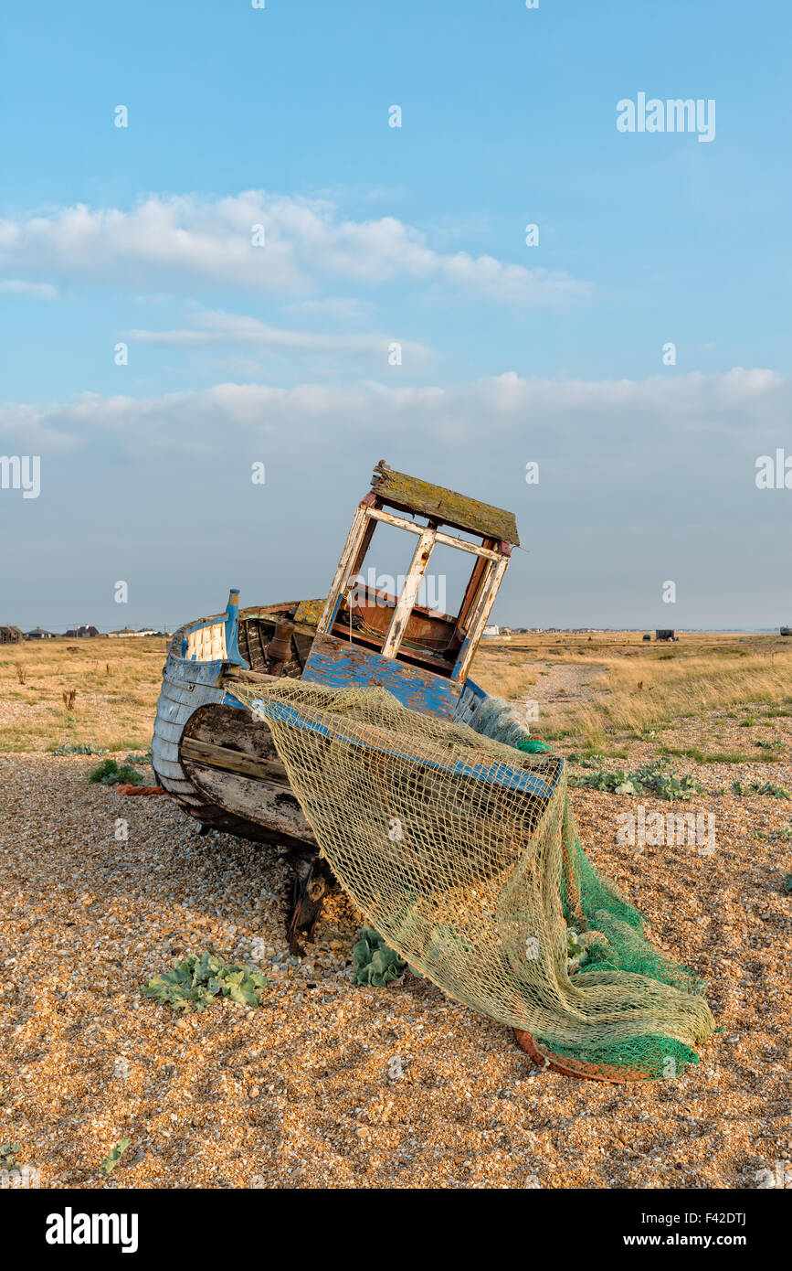 An old wooden fishing boat on a shingle beach at Dungeness on the Kent ...