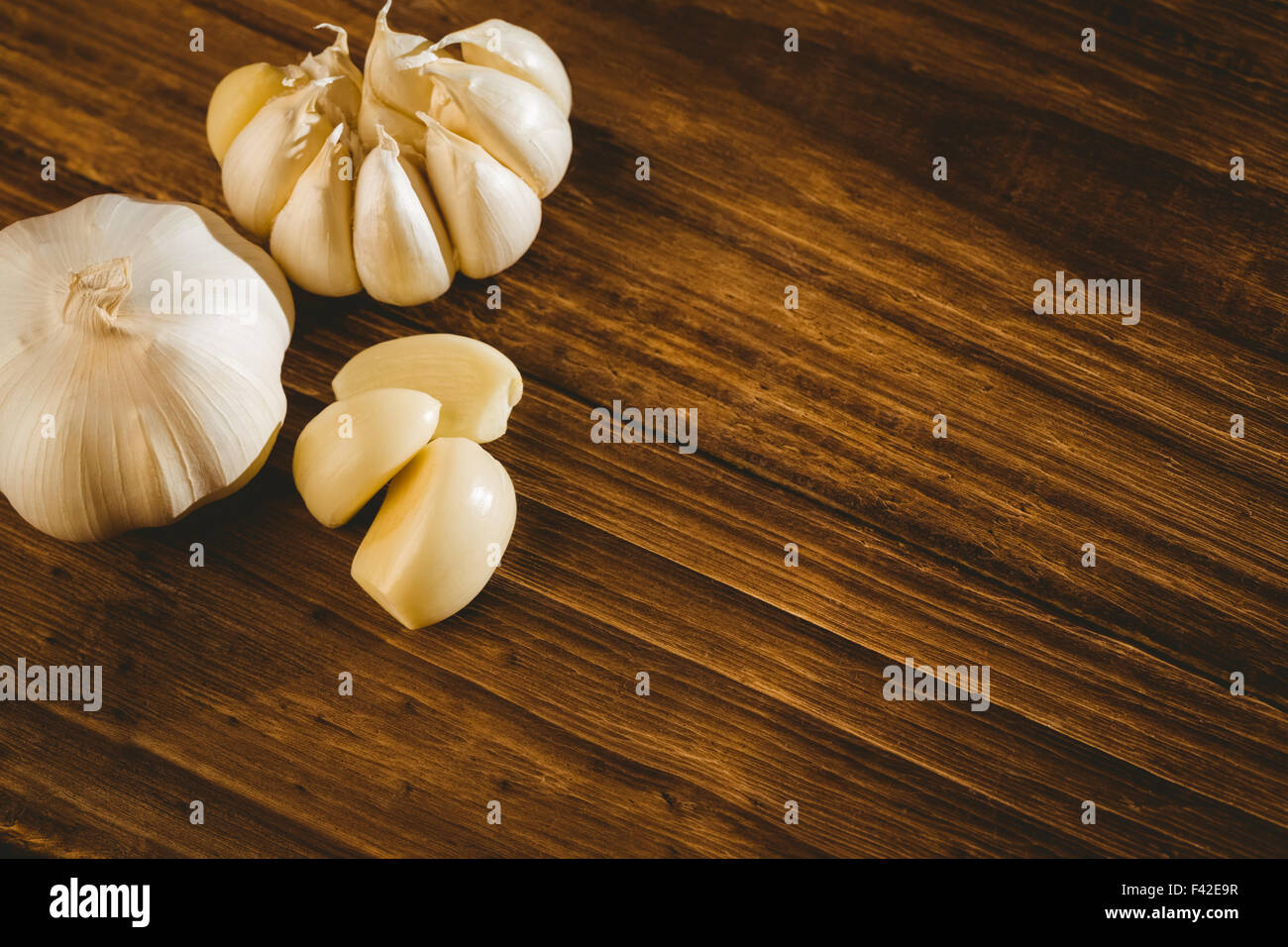 Garlic cloves and bulb on chopping board Stock Photo - Alamy