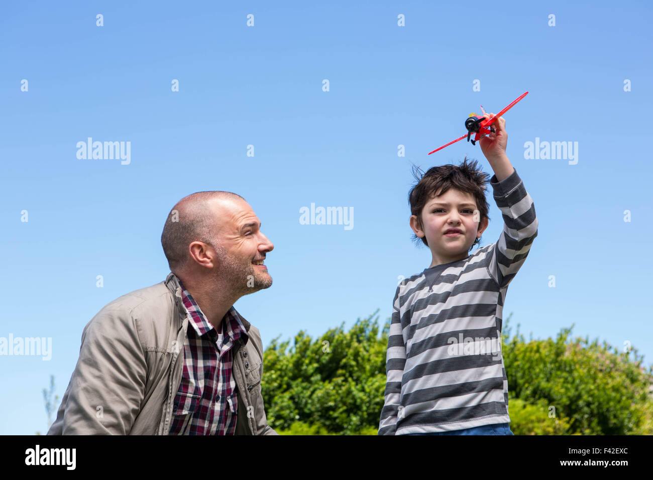 Young boy playing with a toy plane Stock Photo