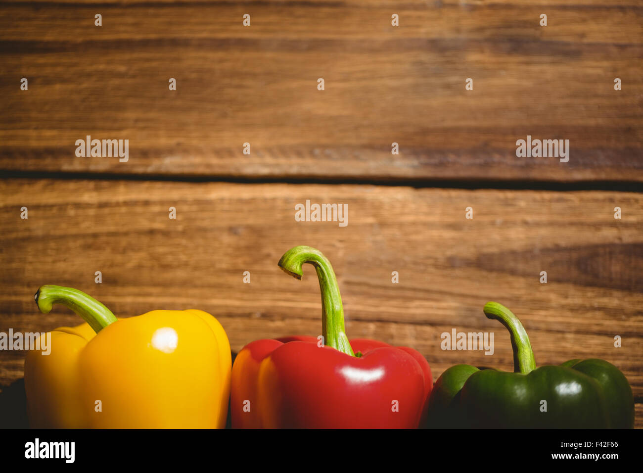 Three peppers on chopping board Stock Photo - Alamy