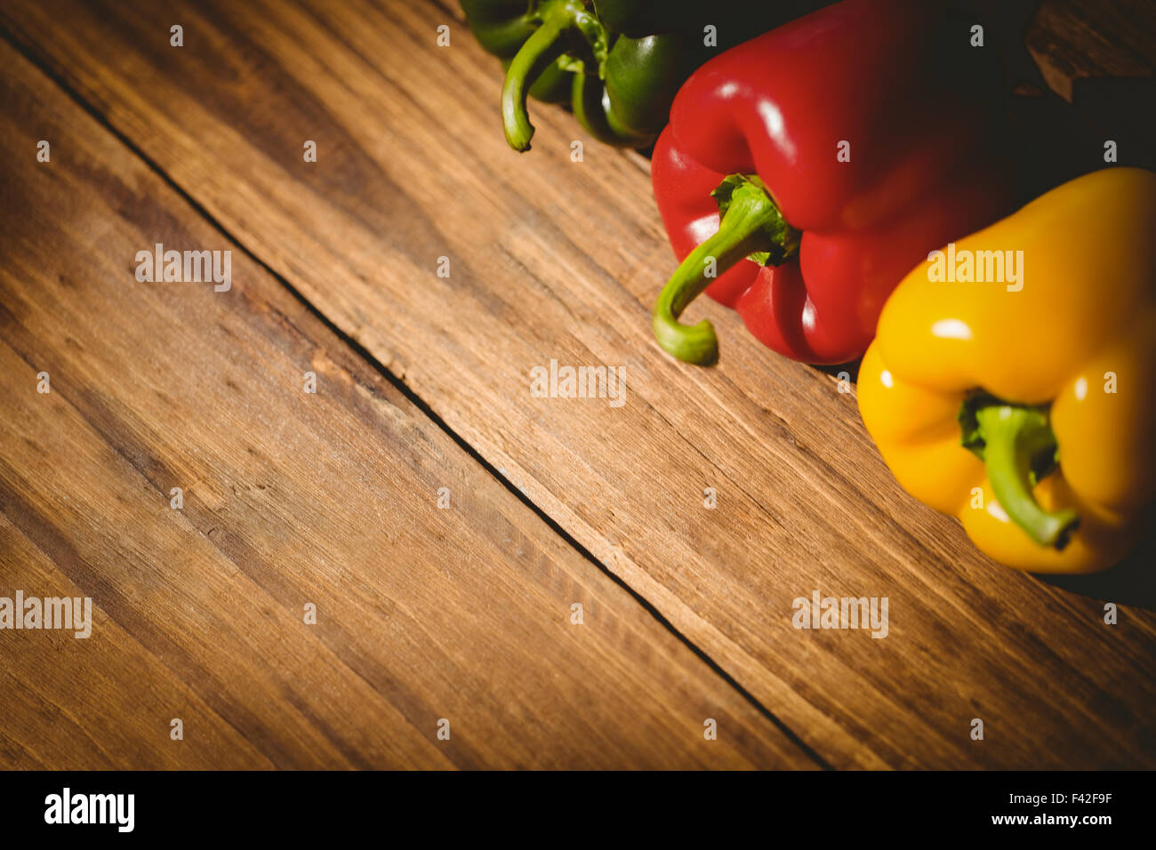 Three peppers on chopping board Stock Photo - Alamy