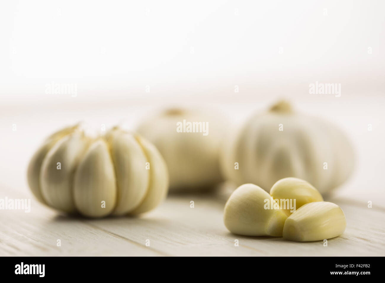 Garlic cloves and bulb on chopping board Stock Photo - Alamy