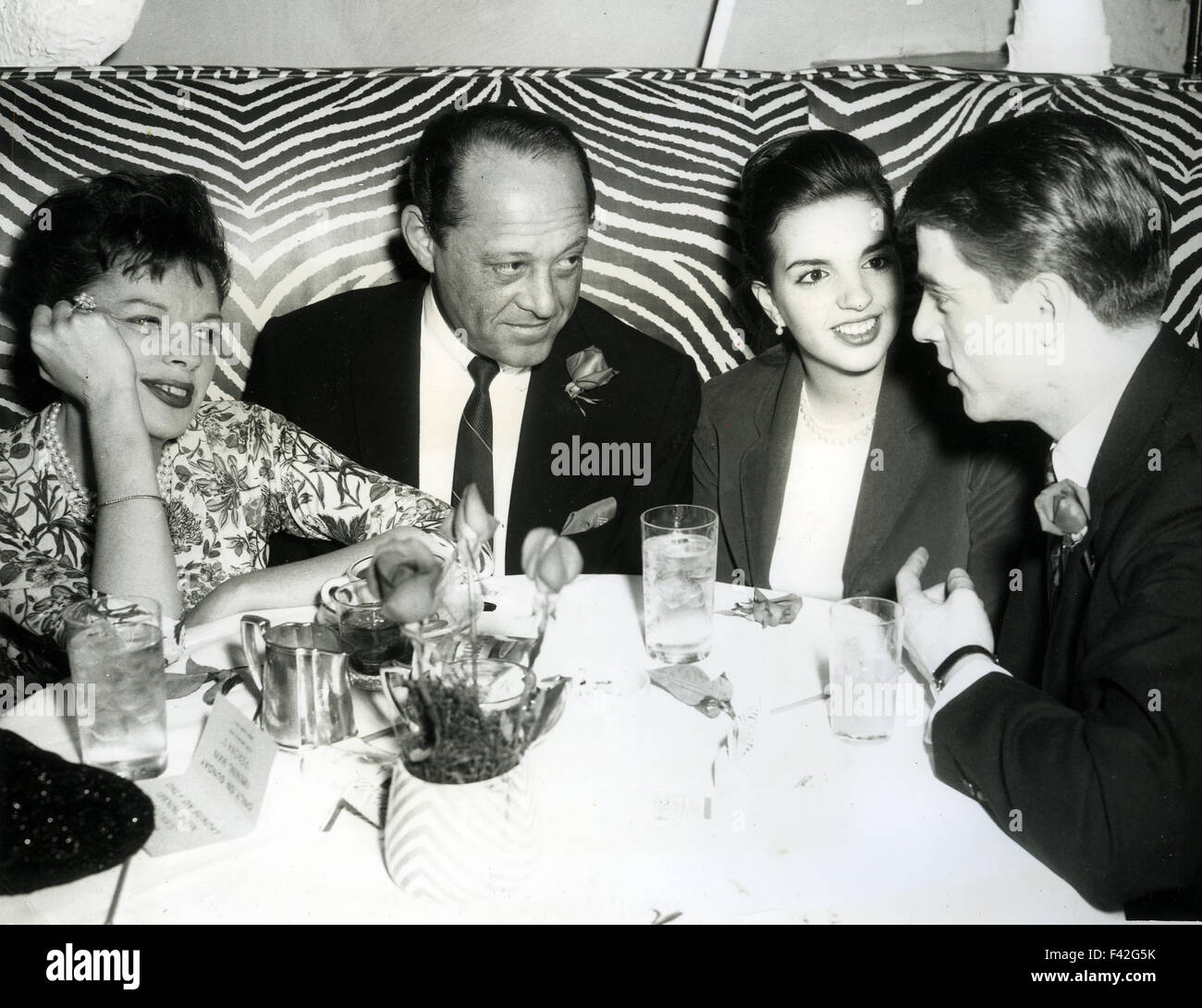 JUDY GARLAND at left with husband Sid Luff at the El Morroco restaurant, New York, in April 1963 celebrating daughter Liza Minnelli's stage debut in Best Foot Forward at the off-Broadway theatre Stage 73. Liza is seated next to dancer Tracy Everett who appeared on several of Judy Garland's TV shows. Stock Photo