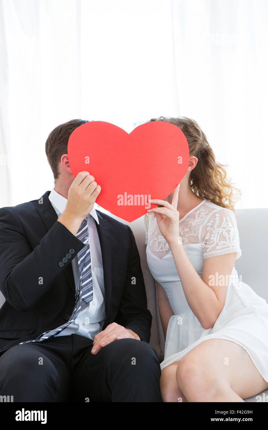 Couple kissing behind heart card Stock Photo - Alamy