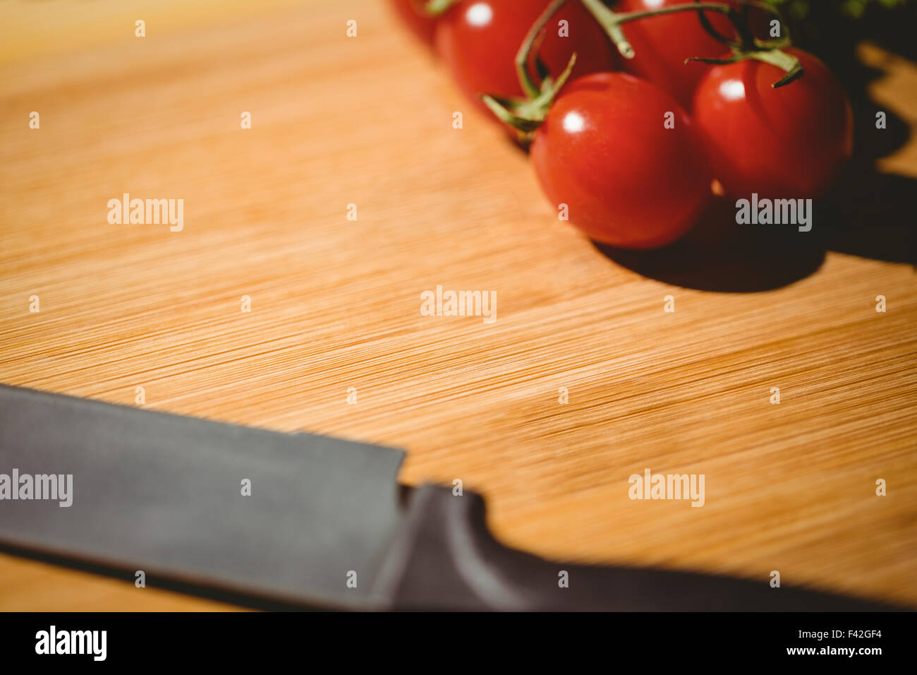 Cherry tomatoes and knife on chopping board Stock Photo - Alamy