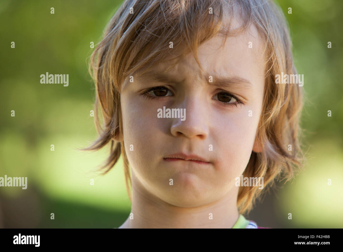 Sad little boy in the park Stock Photo Alamy