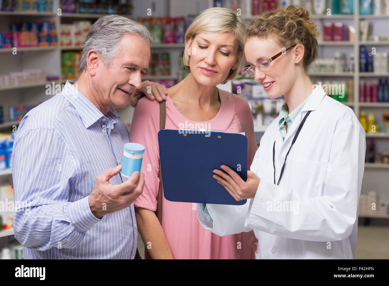 Pharmacist showing clipboard to costumers Stock Photo