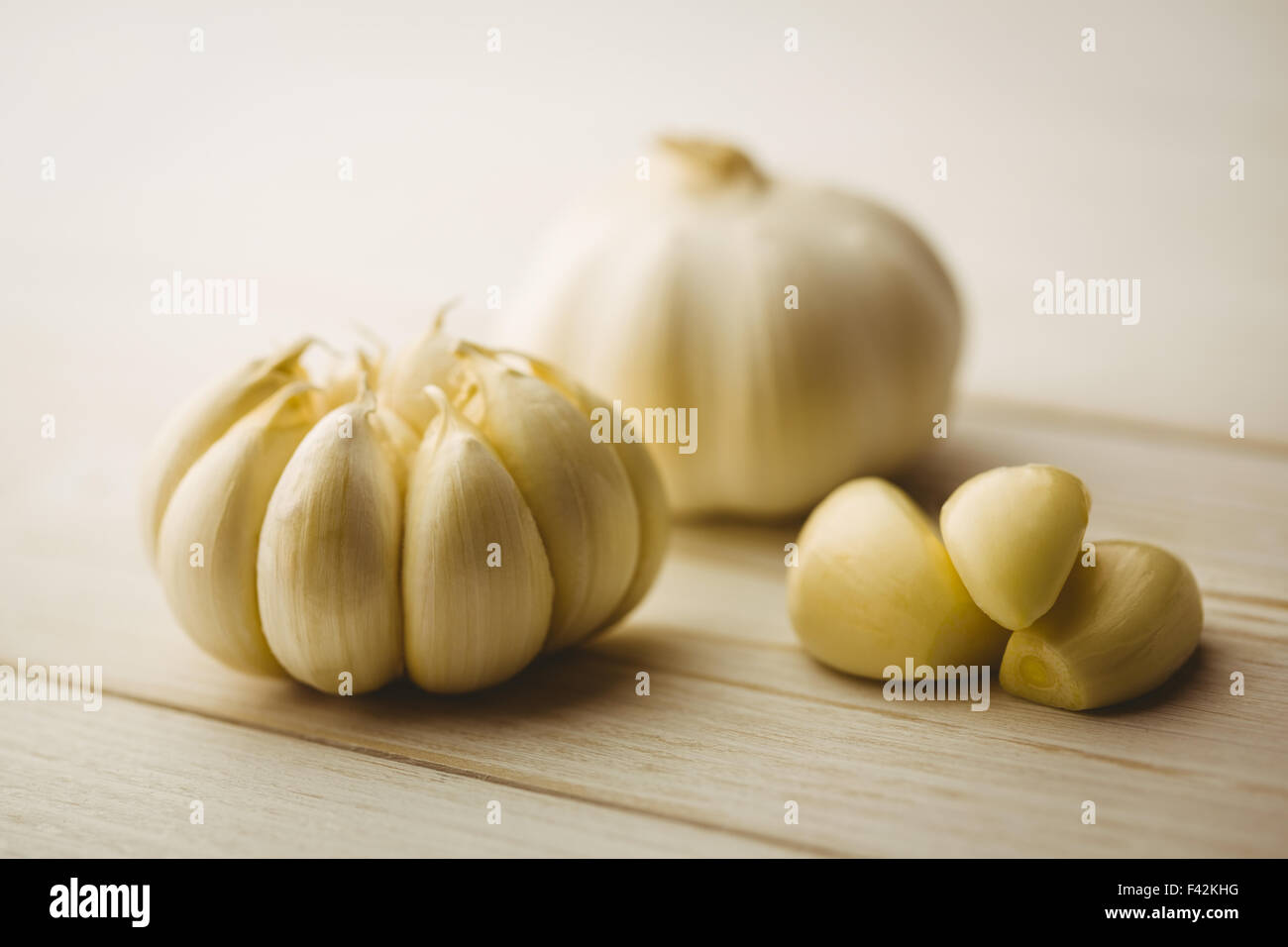 Garlic cloves and bulb on chopping board Stock Photo - Alamy