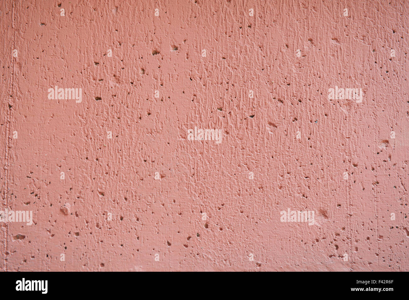 Salmon rough concrete wall uneven abstract background Stock Photo