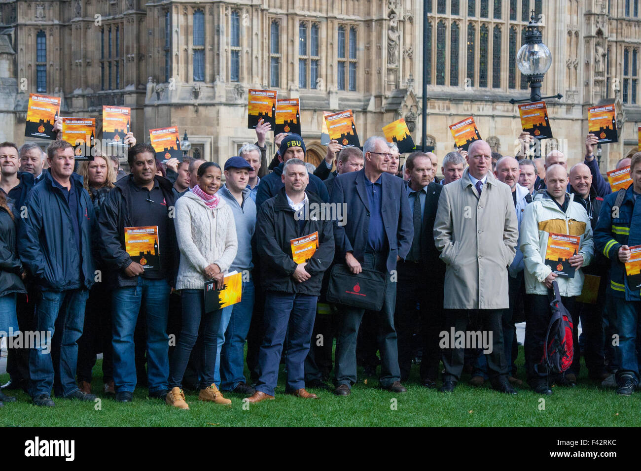 Westminster, London, October 14th 2015. Members of the FBU gather outside Parliament as they prepare to lobby MPs over cuts, the Trade Union Bill and the possibility of their service falling under the control of Police and Crime Commissioners. PICTURED: FBU Members pose for a group shot as they prepare to enter Parliament. Credit:  Paul Davey/Alamy Live News Stock Photo