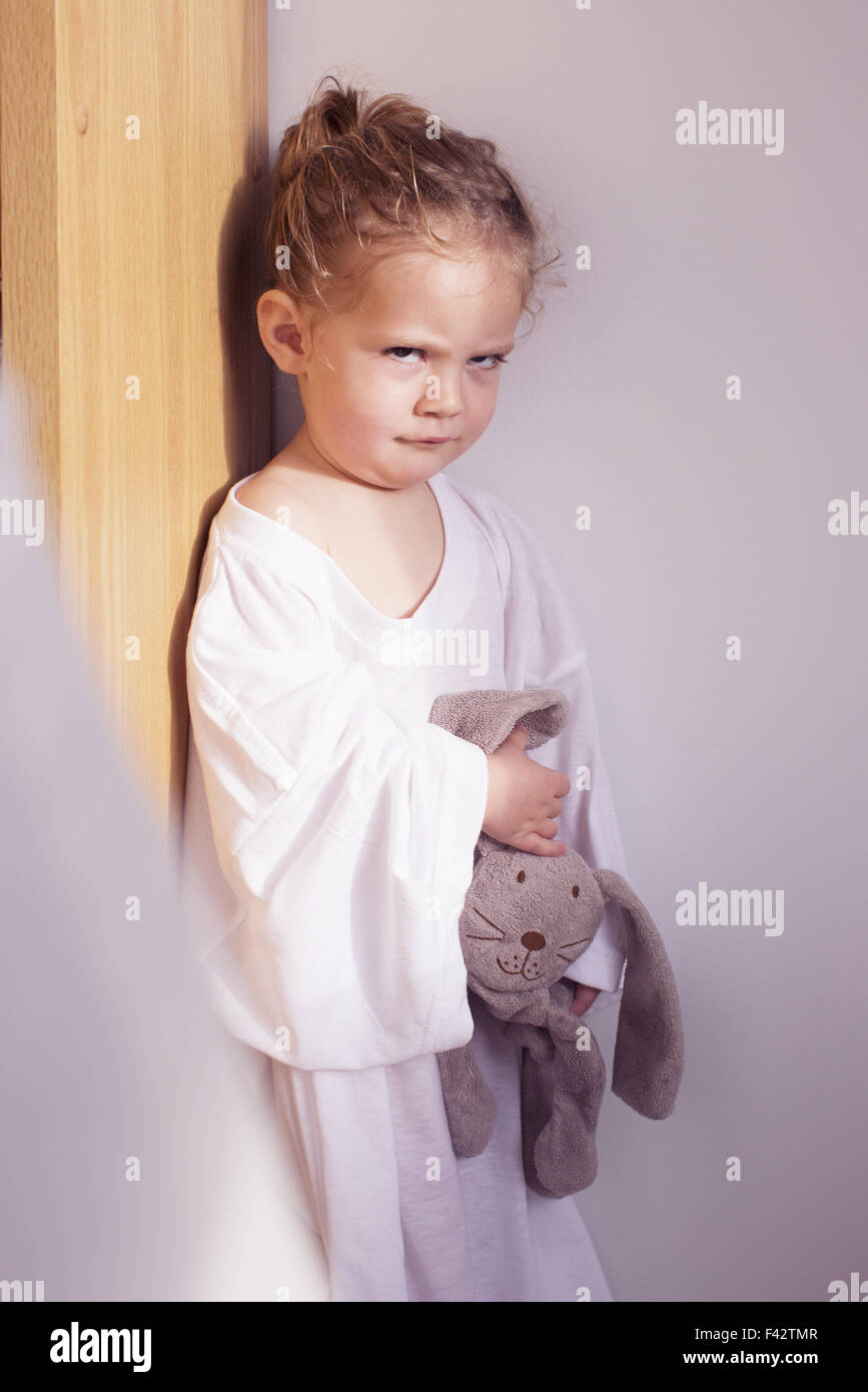 Little girl sulking in corner Stock Photo