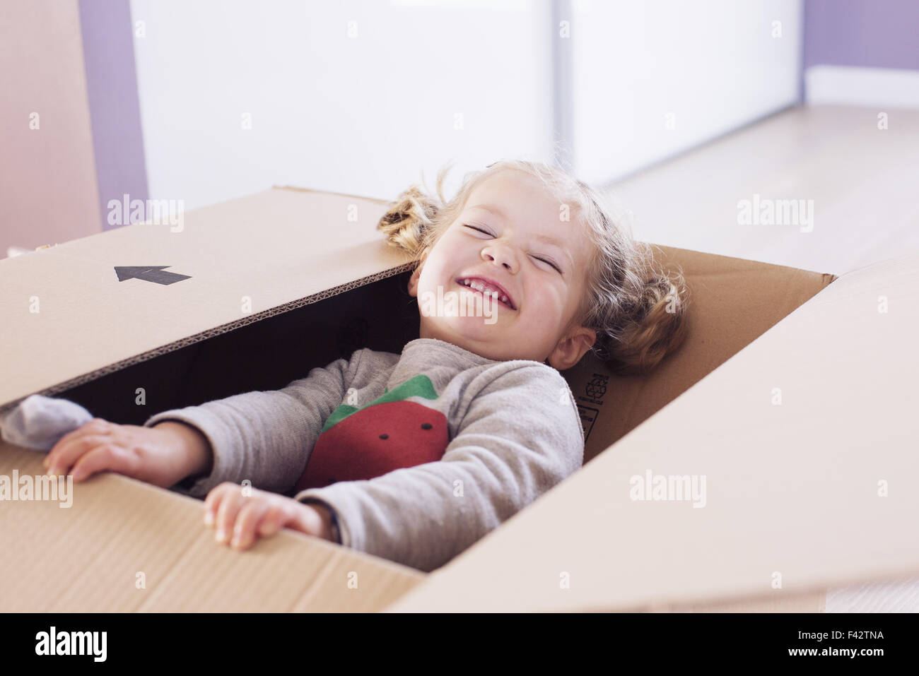 Little girl playing in cardboard box, portrait Stock Photo