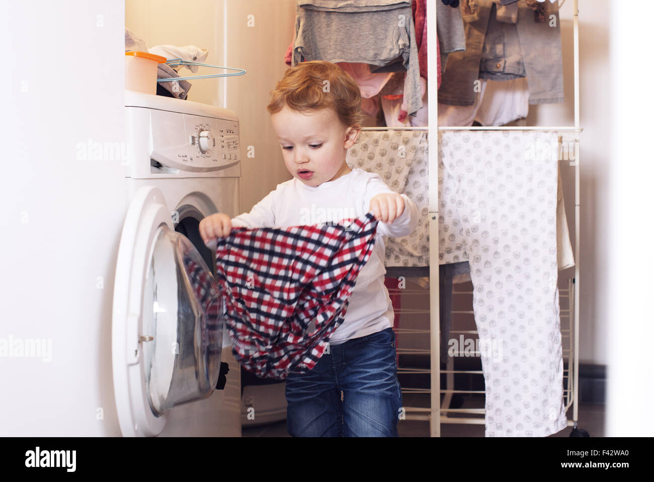 Little boy taking clothes out of dryer Stock Photo Alamy