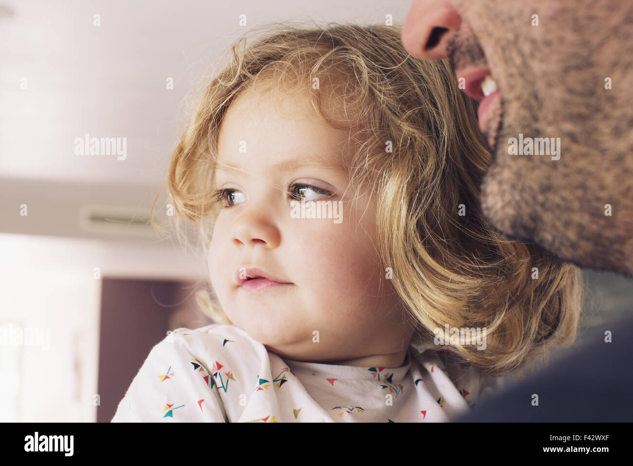 Little girl with father, looking away in interest Stock Photo