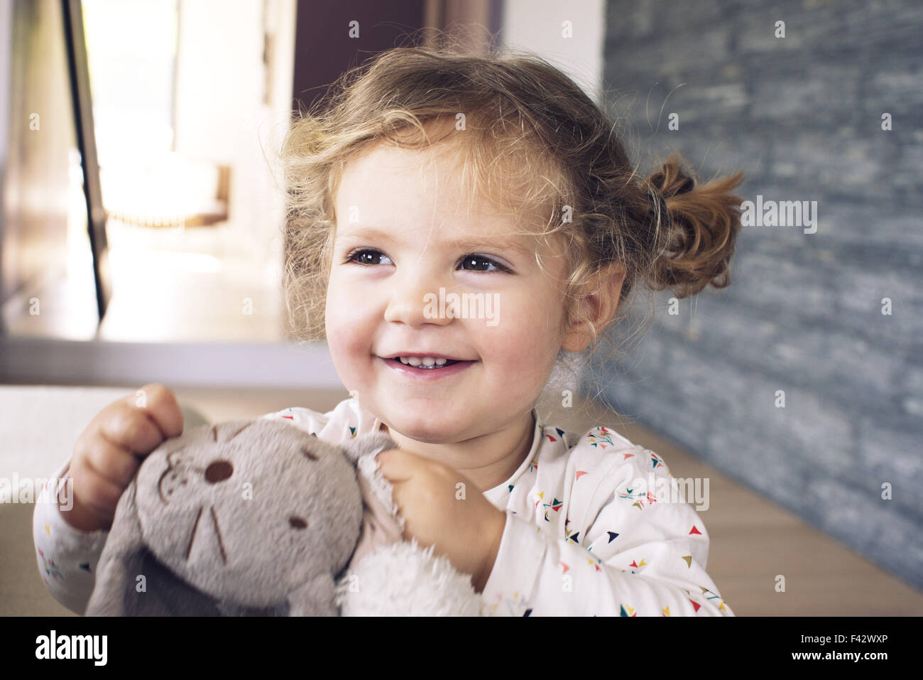 Little girl holding stuffed toy, smiling, portrait Stock Photo